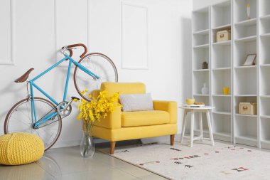 Bisikleti, koltuğu ve raf ünitesi olan modern bir oda.