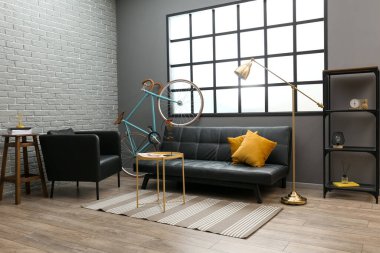 Kanepesi, masası, koltuğu ve bisikleti olan modern bir daire.