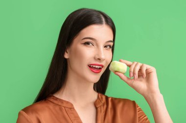 Güzel genç bir kadın arkaplanda lezzetli Japon mochi yiyor.