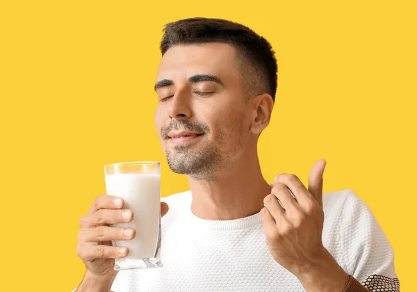 Junger Mann Mit Milchglas Auf Gelbem Hintergrund — Stockfoto