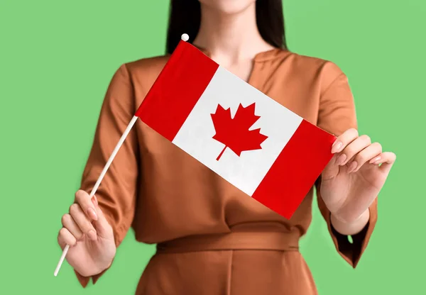 美丽的年轻女子 绿色背景上挂着加拿大国旗 — 图库照片