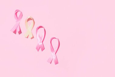 Pembe arka planda farkındalık kurdeleleri. Dünya Kanser Günü