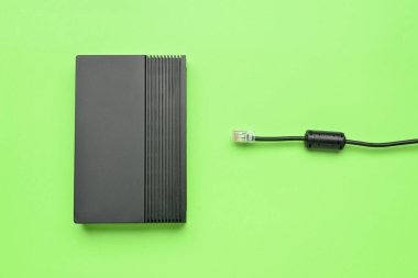 Yeşil arka planda kablosuz ağ yönlendirici ve internet kablosu