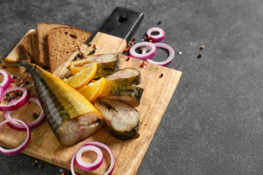 Ahşap tahta füme uskumru balığı ve ekmeği siyah arka planda kesiyor.