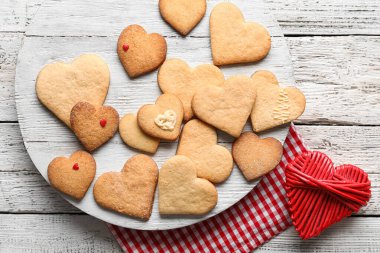 Beyaz ahşap arka planda, nefis kalp şekilli kurabiyeler olan tahta, yakın plan. Sevgililer Günü kutlaması