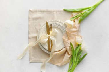 Altın çatal bıçak ve lalelerle donatılmış güzel bir masa.