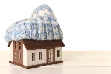 Beyaz arka planda sıcak şapkalı ev modeli. Isıtma kavramı