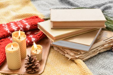 Mum yakan tepsiler ve ekoseli kitaplar.