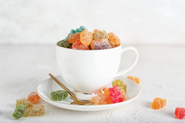 Arka planda farklı jöle ayıcıkları olan fincan.