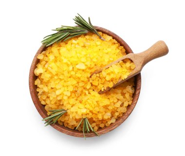 Beyaz arka planda turuncu deniz tuzu, kepçe ve biberiye ile ahşap kase.