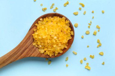 Arkaplanda turuncu deniz tuzu olan tahta kaşık, yakın plan.