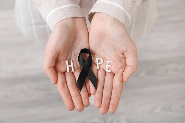 Female Hands Word Hope Black Ribbon Light Background Melanoma Concept — Stock Photo, Image