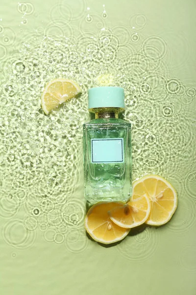 Bottle Perfume Lemon Slices Water Green Background — Stock Photo, Image