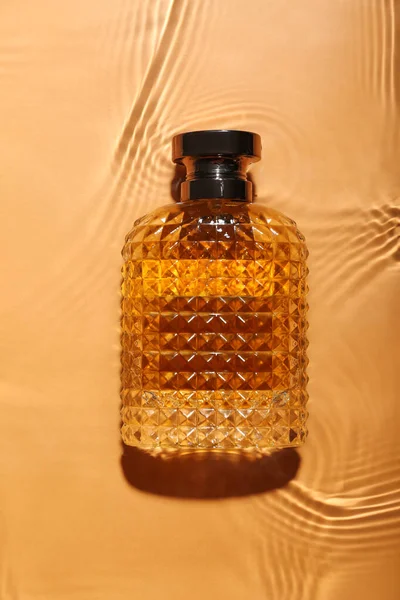 Butelka Perfum Wodzie Pomarańczowym Tle — Zdjęcie stockowe