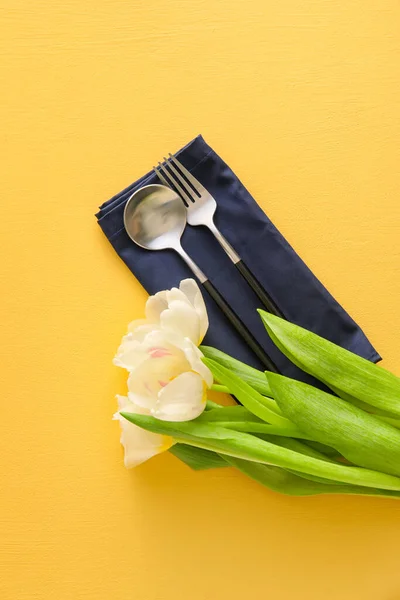 Servett Med Bestick Och Vackra Tulpaner Färg Bakgrund — Stockfoto