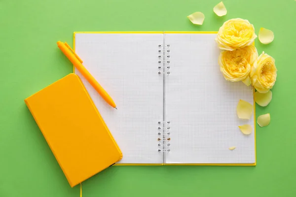 ノートブック ペンと緑の背景にバラの花 — ストック写真