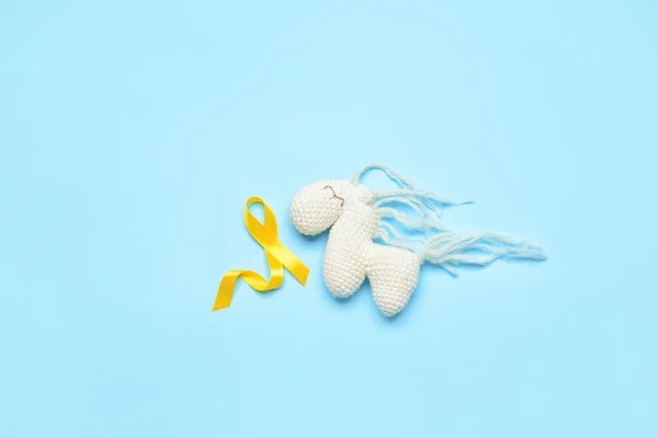 Złota Wstążka Świadomości Koń Zabawka Niebieskim Tle Międzynarodowy Dzień Raka — Zdjęcie stockowe