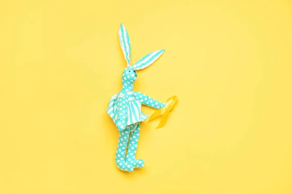 Toy Rabbit Golden Awareness Ribbon Yellow Background International Childhood Cancer — Stock Photo, Image