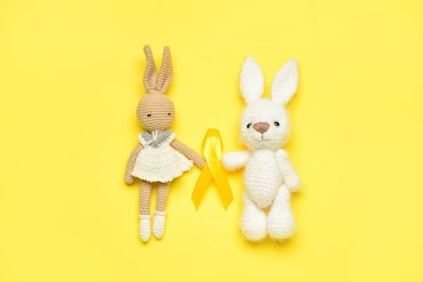 Toy Rabbits Golden Awareness Ribbon Yellow Background International Childhood Cancer — Stock Photo, Image