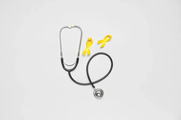 Goldene Bewusstseinsbänder Und Stethoskop Auf Hellem Hintergrund Internationaler Kinderkrebstag — Stockfoto