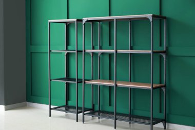 Odadaki yeşil duvarın yanındaki boş raflar