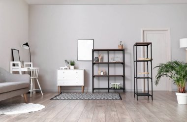 İçinde raf üniteleri, modern mobilyalar ve boş fotoğraf çerçeveleri olan bir oda.