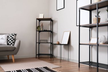 Dekorlu raf ünitesi ve ışık duvarının yanında boş fotoğraf çerçeveleri