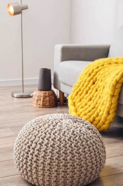 Hafif oturma odasındaki ahşap zeminde rahat bir puf.