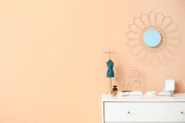 Renkli duvarın yanındaki çekmecelerde şık mücevherler.