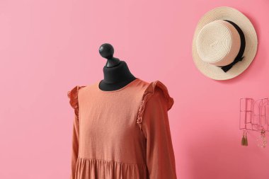 Renkli duvarında hasır şapkası ve elbisesi olan manken.