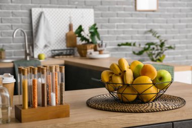 Mutfaktaki masada farklı meyveler olan sepet.