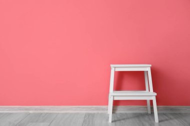 Odanın renkli duvarının yanındaki beyaz merdiven.