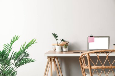 Laptop ve hasır koltuklu modern işyeri