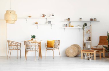 Hasır sandalyeli ve masalı hafif yemek odasının içi.