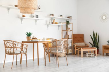 Hasır sandalyeli ve masalı hafif yemek odasının içi.