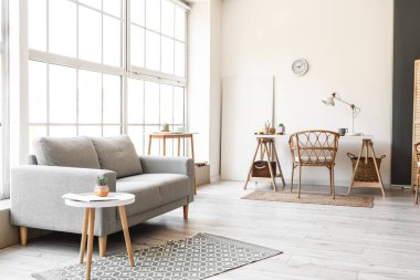 Kanepe, işyeri ve büyük pencereli aydınlık oturma odasının içi.