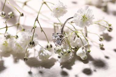 Beyaz çiçekli güzel gümüş nişan yüzüğü, yakın plan.