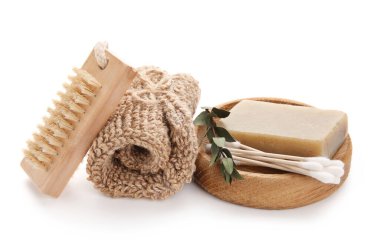 Beyaz arka planda sabun, pamuklu bez, sünger ve masaj fırçası.