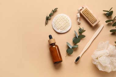 Banyo malzemeleri, gerekli yağ şişesi ve renk arkaplanındaki okaliptüs dallarıyla kompozisyon