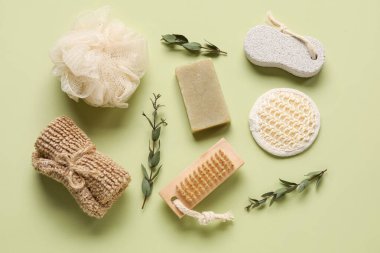 Yeşil arka planda banyo malzemeleri ve okaliptüs dalları.