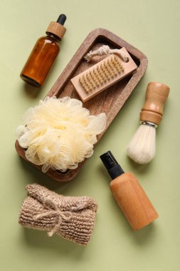 Yeşil arka planda banyo malzemeleri ve kozmetik ürünleri.