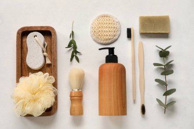 Banyo malzemeleri ve arka planda okaliptüs dalları olan kompozisyon