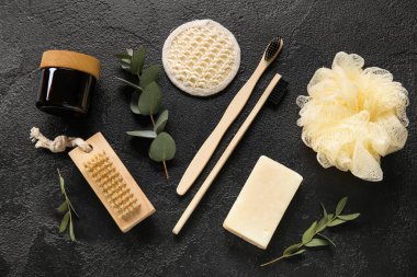 Banyo malzemeleri, kozmetik ürünleri ve koyu arkaplanda okaliptüs dalları ile kompozisyon