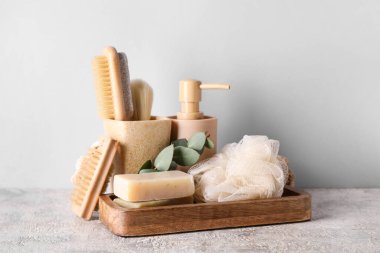 Açık arkaplanda sabun parçaları olan farklı banyo malzemeleri.