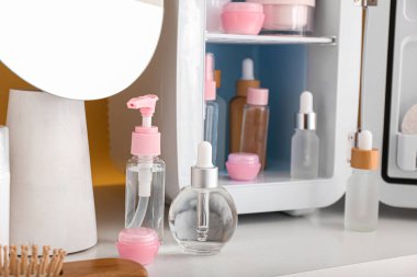 Masada kozmetik ürünleri olan küçük buzdolabı, yakın plan.