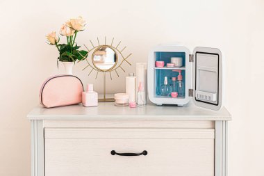 Küçük buzdolabı ve kozmetik ürünleri olan çekmeceler.