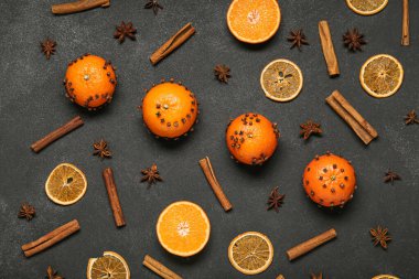 Koyu arkaplanda karanfil bulunan mandalinalardan yapılmış el yapımı Noel süsü.