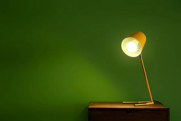 傍晚时分 靠近彩墙的木制桌子上闪烁着一盏灯 — 图库照片
