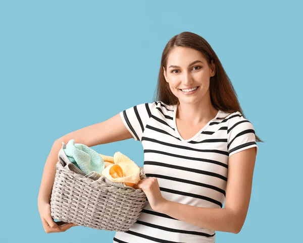 漂亮的家庭主妇 蓝色背景的柳条篮里有洗衣服 — 图库照片