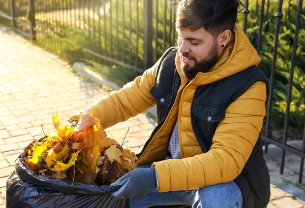 秋の紅葉を集める男 — ストック写真